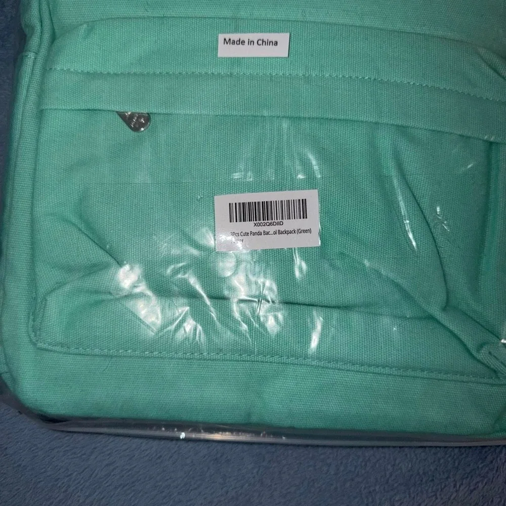 Green backpack with white panda graphics